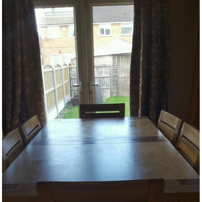 Dining room extending oak table and 6 oak with brown leather seat chairs