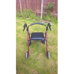 Four wheeled walking frame with seat and brakes