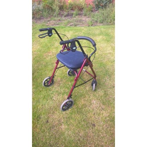 Four wheeled walking frame with seat and brakes