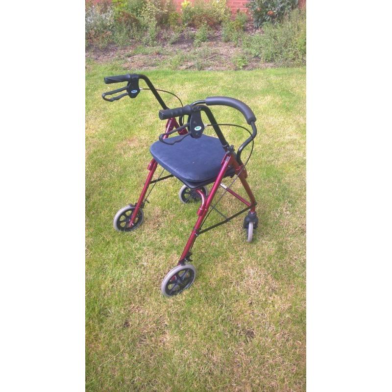 Four wheeled walking frame with seat and brakes