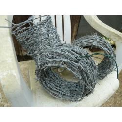 Three new rolls of barbed wire, length unsure.