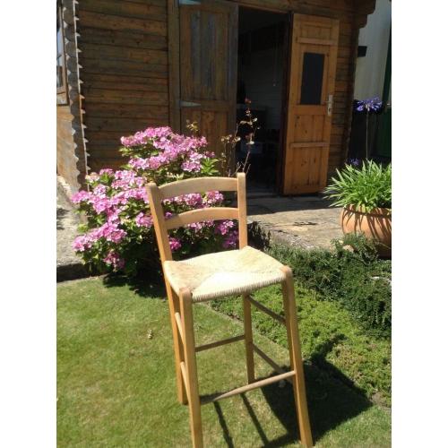 Two bar chairs/stools made of light coloured wood with string seating. In fair condition
