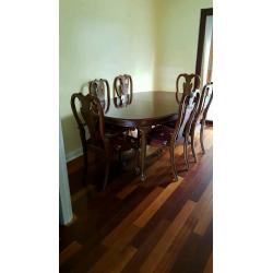 Oval mahogany dining room table with 6 matching chairs.